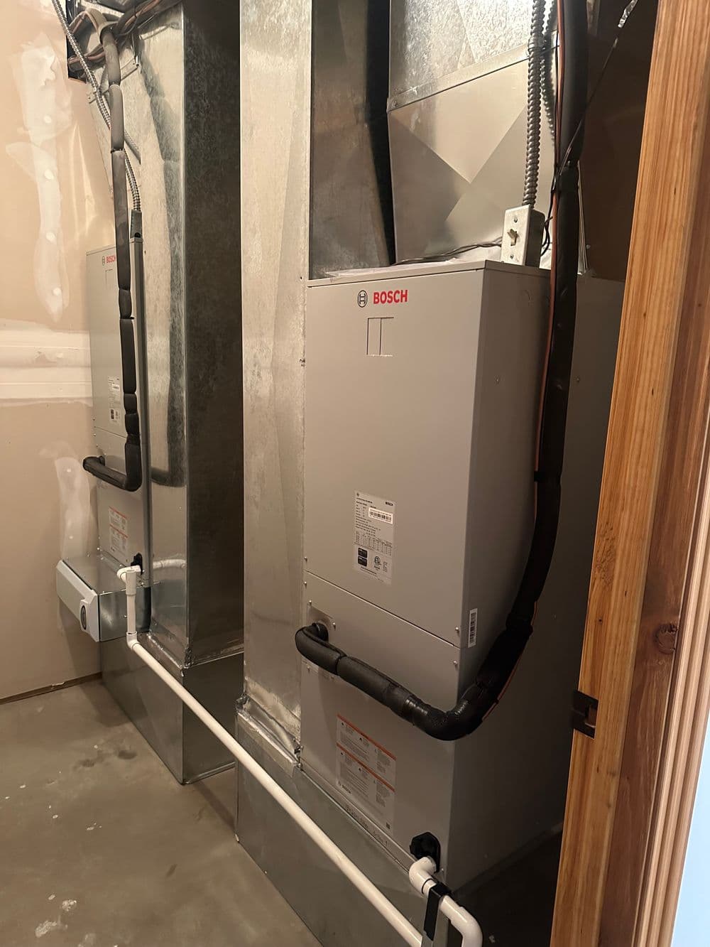 Bosch heating system installed in a basement with ductwork and piping visible.