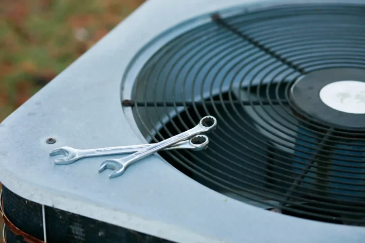 An outdoor AC Unit ready to be replaced using tools